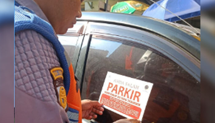Petugas Dishub Kota Sukabumi Pasang Stiker di Mobil Parkir Sembarangan di Jalan Ahmad Yani