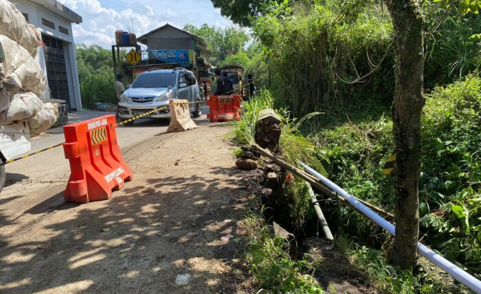 Sejumlah kendaraan melintas di atas jembatan kecil yang amblas tergerus longsor di jalan alternatif Karangtengah-Pamuruyan di Kecamatan Cibadak, Kabupaten Sukabumi, Sabtu (02/05/2026).