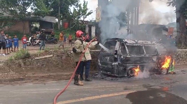 Petugas pemadam kebakaran berupaya memadamkan api yang menghanguskan sebuah angkot di Desa Sekarwangi, Kecamatan Cibadak, Kabupaten Sukabumi, Minggu (10/05/2026).